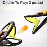 Two yellow and black hand-held mesh catch paddles with an orange ball in motion