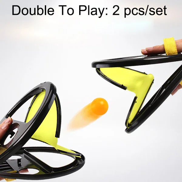 Two yellow and black hand-held mesh catch paddles with an orange ball in motion