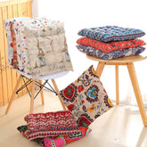 Stack of colorful, patterned cotton cushions with soft, quilted texture on chairs