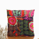 Square throw pillow with vibrant multicolor patchwork, bold patterns, and soft fabric