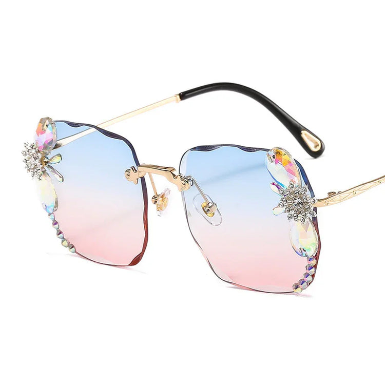 Gradient blue and pink rimless sunglasses with crystal flower accents and gold metal arms