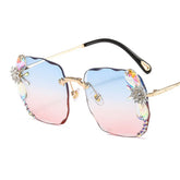 Gradient rimless sunglasses with blue and pink lenses, gold temples, jewel accents, and butterfly decor