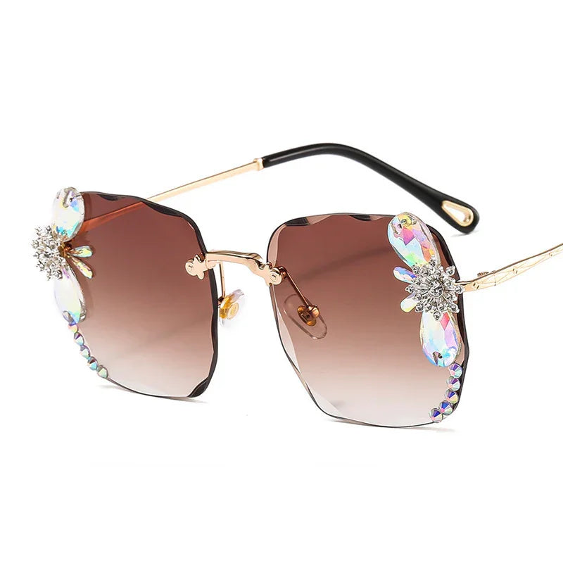 Square oversized sunglasses with brown gradient lenses, crystal flower accents, and gold metal arms