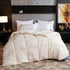 Soft cream quilted comforter with plush texture and relaxed fit on modern bed
