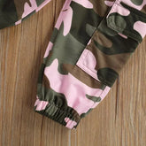 Pink and green camo cargo pants with elastic cuffs and pocket detail on wood surface