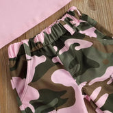 Pink and green camouflage cargo pants with elastic waist, cotton fabric, relaxed fit on wood