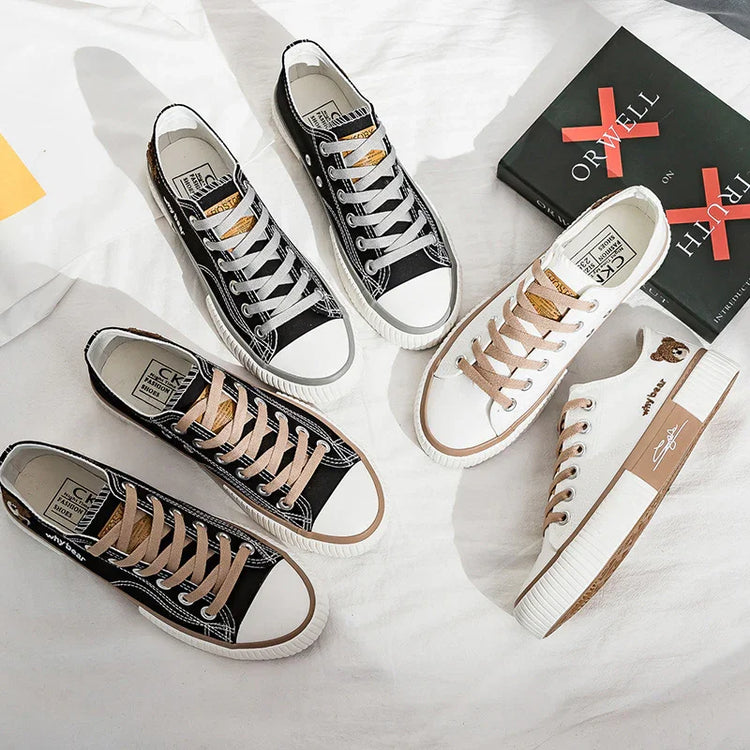 Canvas low-top sneakers in black and white with contrast laces, casual streetwear style.