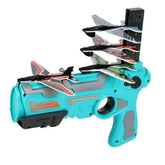 Turquoise and gray plastic toy blaster with multiple foam glider airplanes loaded on top