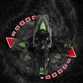 Black and green futuristic toy motorcycle spinning on textured dark surface, overhead view