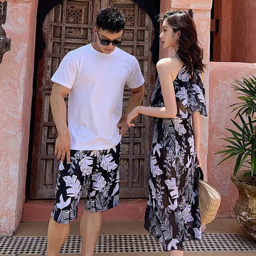 Couple wearing matching black and white floral outfits, man in shorts and T-shirt, woman in flowy dress