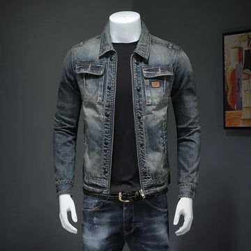 Men's slim-fit faded denim jacket with chest pockets, paired with dark jeans and a black shirt.