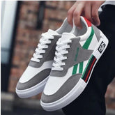 White and gray low-top sneakers with green and red accents, lace-up, casual streetwear style