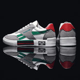 Gray suede low-top sneakers with green stripes, red heel accents, and white rubber soles