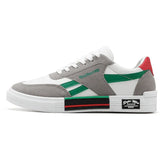 White and grey low-top sneaker with green and red accents, suede overlays, chunky sole