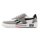 White and gray low-top sneaker with black accents, suede overlays, and a chunky sole