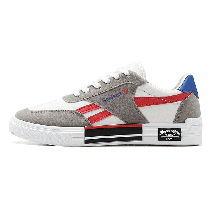 White low-top sneaker with grey suede overlays, red accents, blue heel, and chunky sole