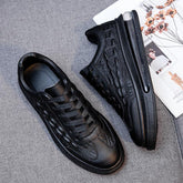 Black low-top sneakers with faux crocodile leather texture, lace-up, and sleek fit