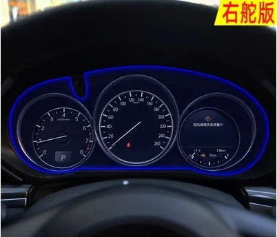 LED illuminated car dashboard cluster with speedometer and fuel gauge in a dark interior