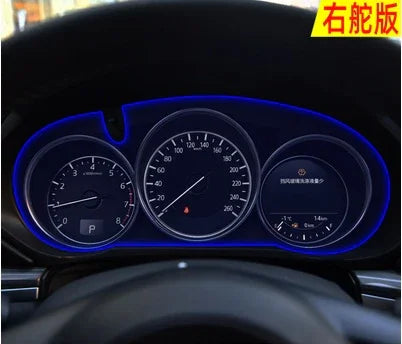 LED illuminated car dashboard cluster with speedometer and fuel gauge in a dark interior