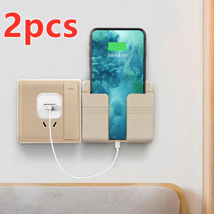 Beige wall-mounted plastic phone holder for charging, shown with a smartphone and power outlet.