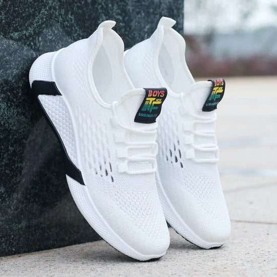 White mesh-knit sneakers with black outsole detail, slip-on fit, outdoor setting