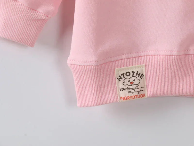 Light pink cotton sweatshirt with ribbed hem and decorative patch detail, relaxed fit