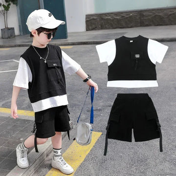 Boy wearing black and white layered streetwear set with cargo shorts and pocket vest.