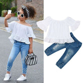 Girl wearing off-shoulder white lace top with ruffle sleeves and distressed pearl jeans