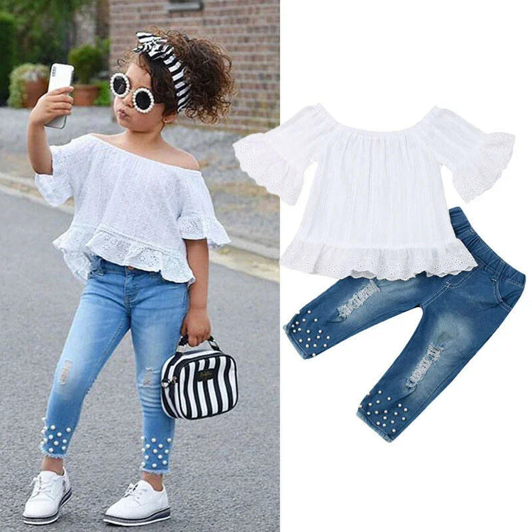 Girl wearing off-shoulder white lace top with ruffle sleeves and distressed pearl jeans