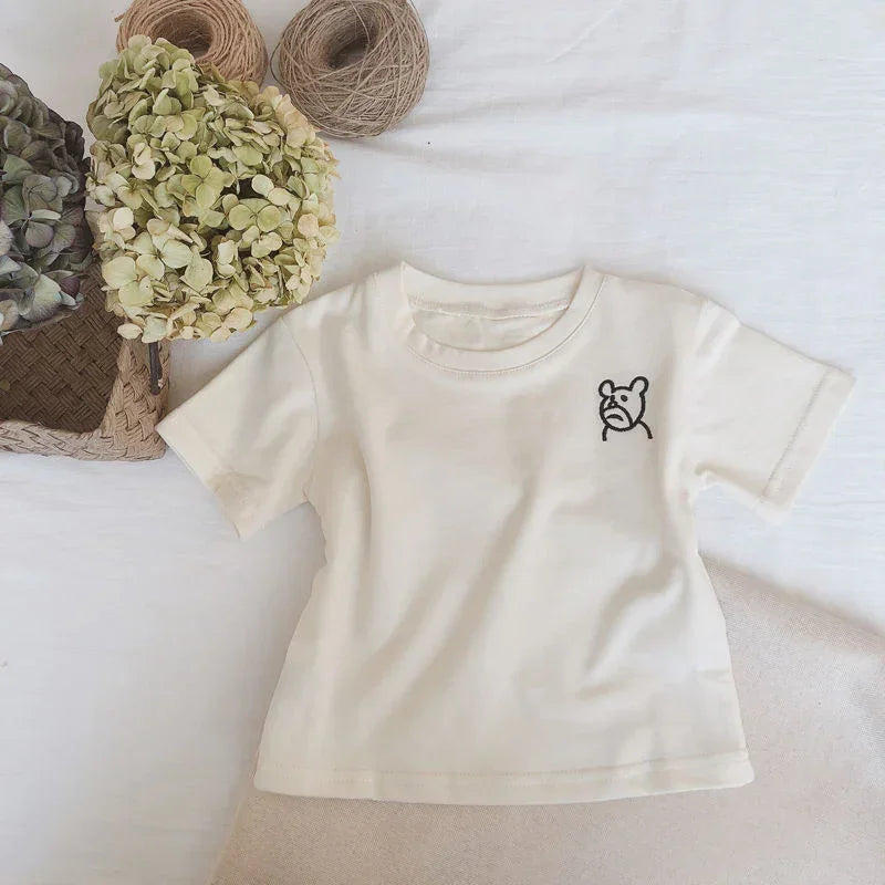 Beige short sleeve cotton t-shirt with small bear graphic, relaxed fit, flat lay style