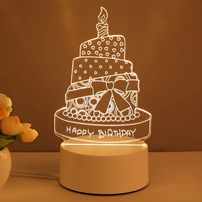 LED acrylic birthday cake night light with white base, glowing in a warm room setting