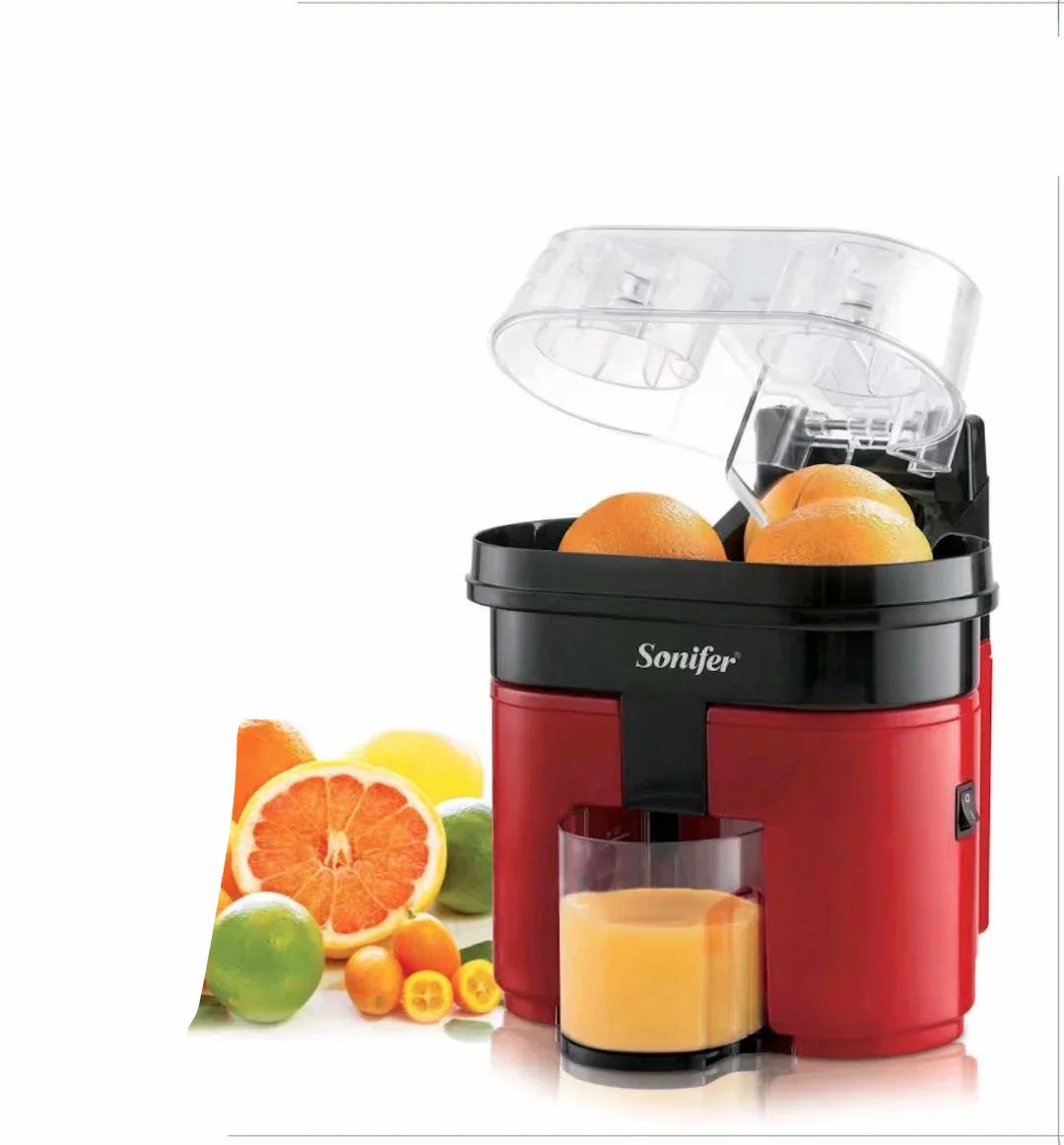 Red and black citrus juicer with oranges, glass of fresh juice, assorted fruits beside