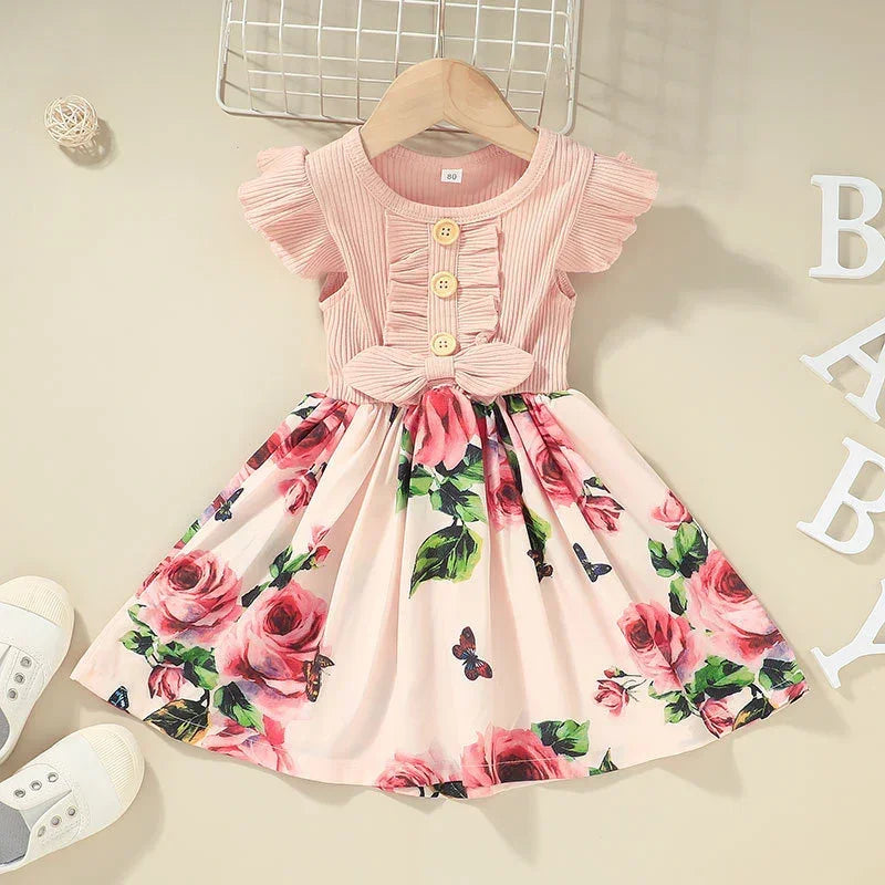 Pink floral short sleeve toddler dress with ruffle sleeves, bow waist, and button details