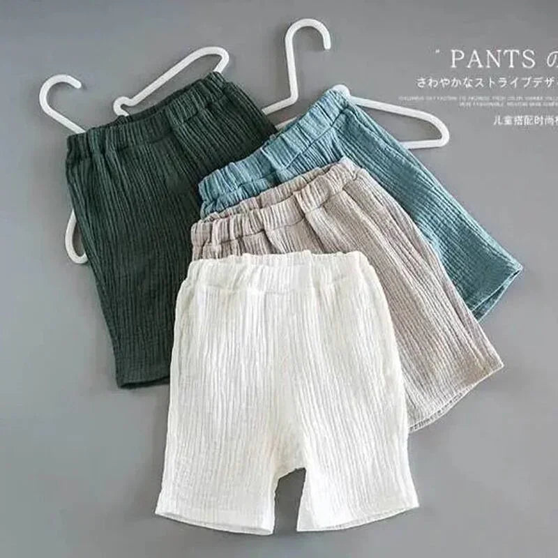Set of four relaxed fit, textured cotton shorts in green, blue, beige, and white.