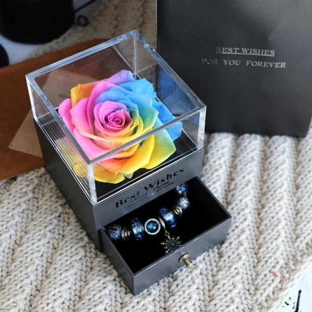 Rainbow preserved rose in a clear acrylic box with a black drawer containing beaded jewelry