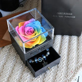 Rainbow preserved rose in a clear acrylic box with a black drawer containing beaded jewelry
