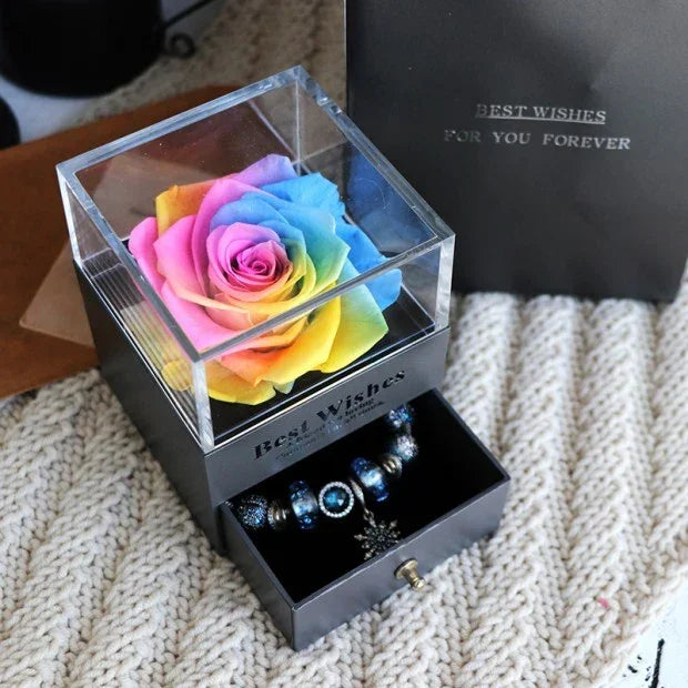 Rainbow preserved rose in a clear acrylic box with a black drawer containing beaded jewelry