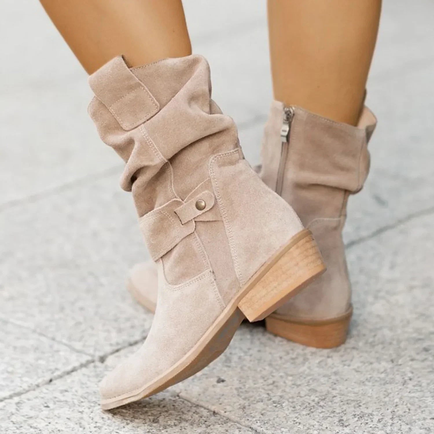 Beige suede mid-calf boots with slouchy fit and chunky low heel on pavement
