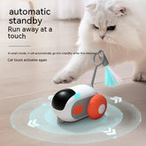 White fluffy cat playing with interactive automatic moving cat toy with colorful feather attachment on wooden floor.