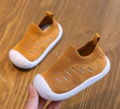 Brown knit slip-on baby shoes with white rubber soles and breathable mesh design.