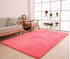 Modern living room with a large pink plush area rug on light wood flooring
