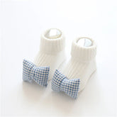 White ribbed knit baby socks with blue gingham bow accents, soft and snug fit.