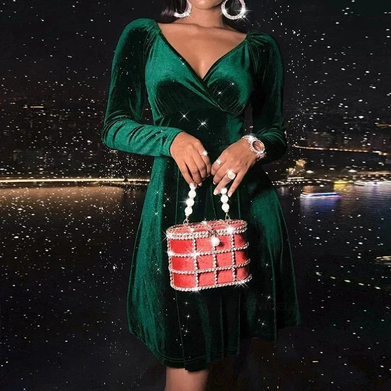 Woman in green velvet long sleeve dress with deep V-neck and A-line fit, holding red pearl handbag