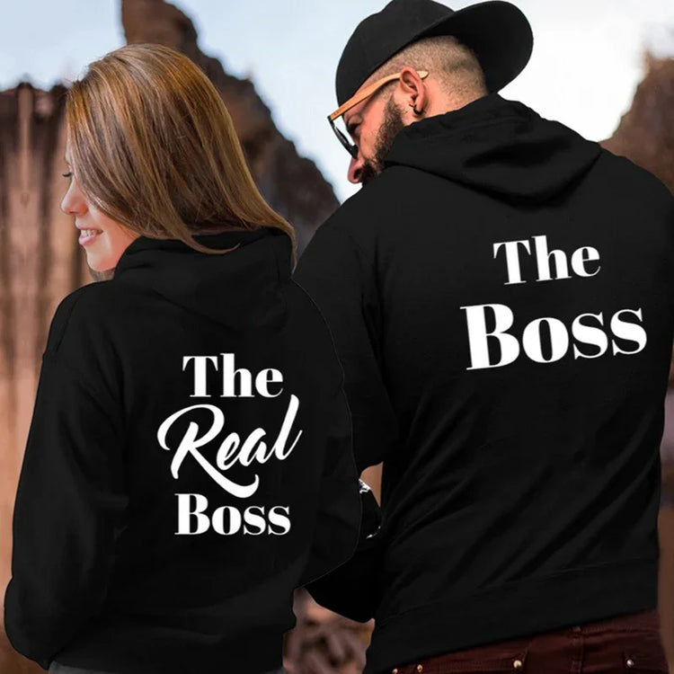Couple wearing black streetwear hoodies with white &