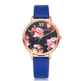 Rose gold watch with blue leather strap and floral print dial, feminine modern style