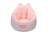 Soft pink and gray plush chair with bear ears, cozy faux fur material, rounded fit.