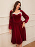 Woman wearing a velvet red midi dress with long sleeves and white faux fur trim, relaxed fit