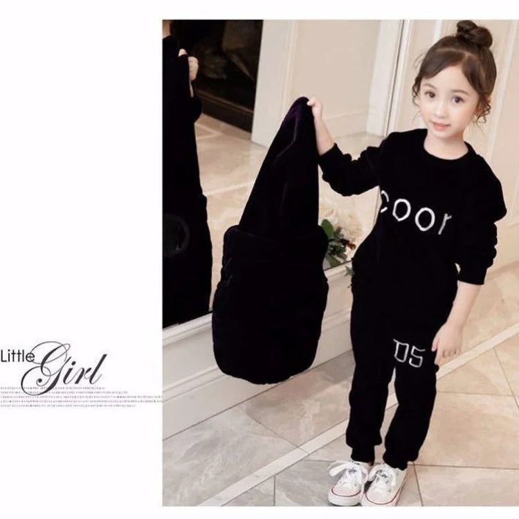 Little girl in black velvet matching sweatshirt and jogger pants set with white sneakers