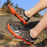 Black and orange lightweight mesh sneakers with geometric pattern, low-cut fit, outdoor setting
