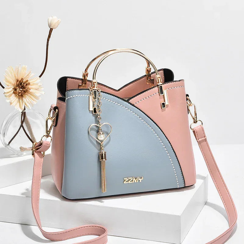 Pastel pink and blue faux leather handbag with gold handles and heart tassel charm
